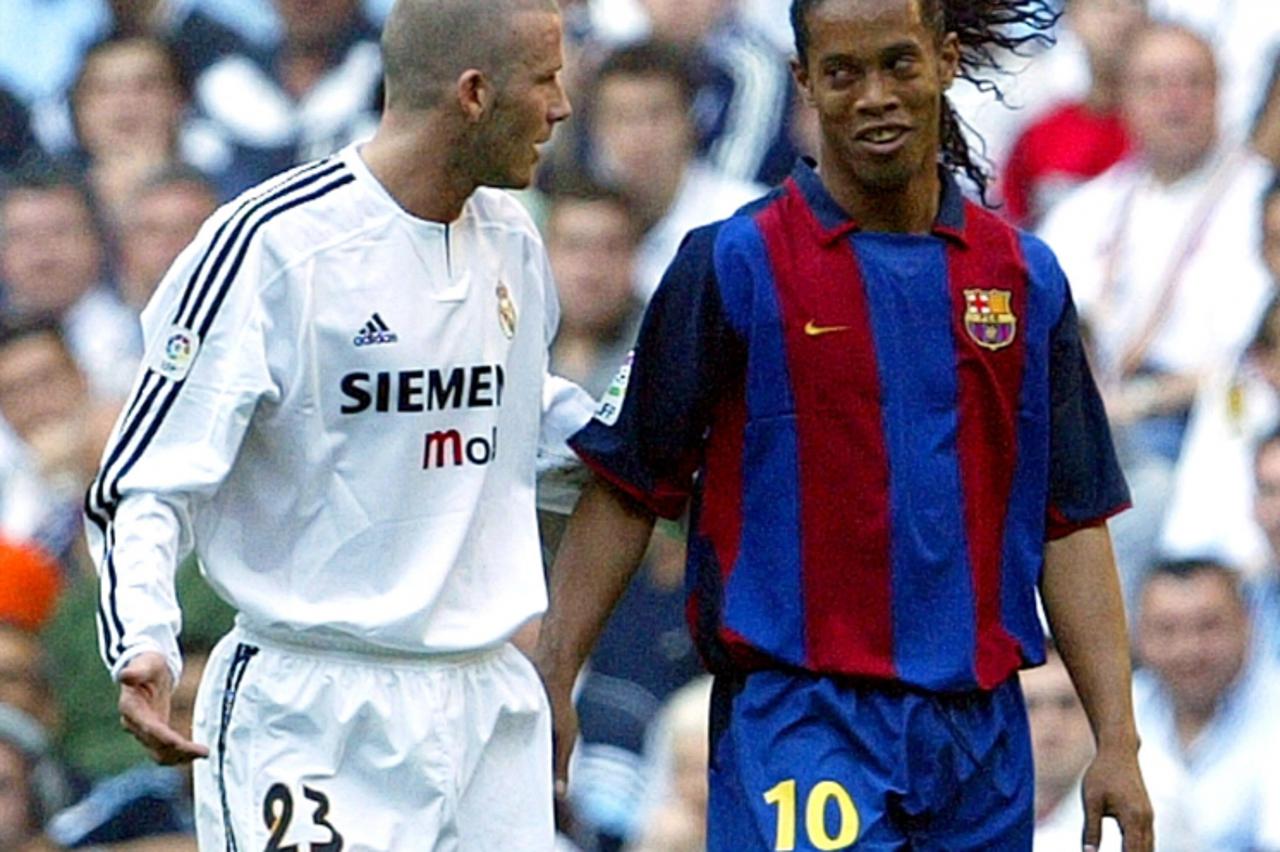 \'Barcelona\'s Brazilian Ronaldinho (R) talks to Real Madrid\'s David Beckham during their First Division soccer match at Madrid\'s Santiago Bernabeu stadium, April 25, 2004. REUTERS/Andrea Comas REUT